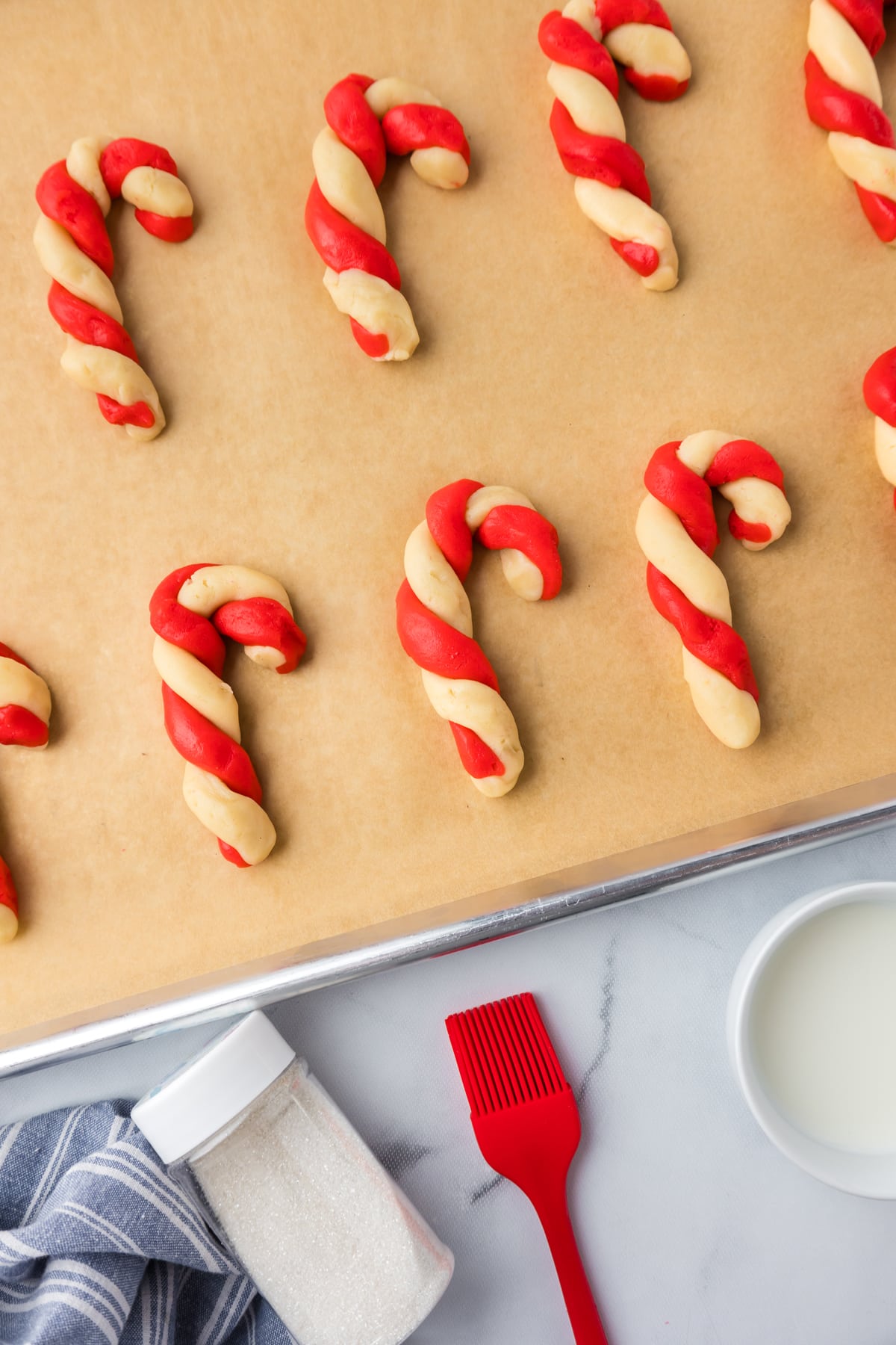 Candy Cane Cookies on a parchment paper lined cookie sheet before baking.