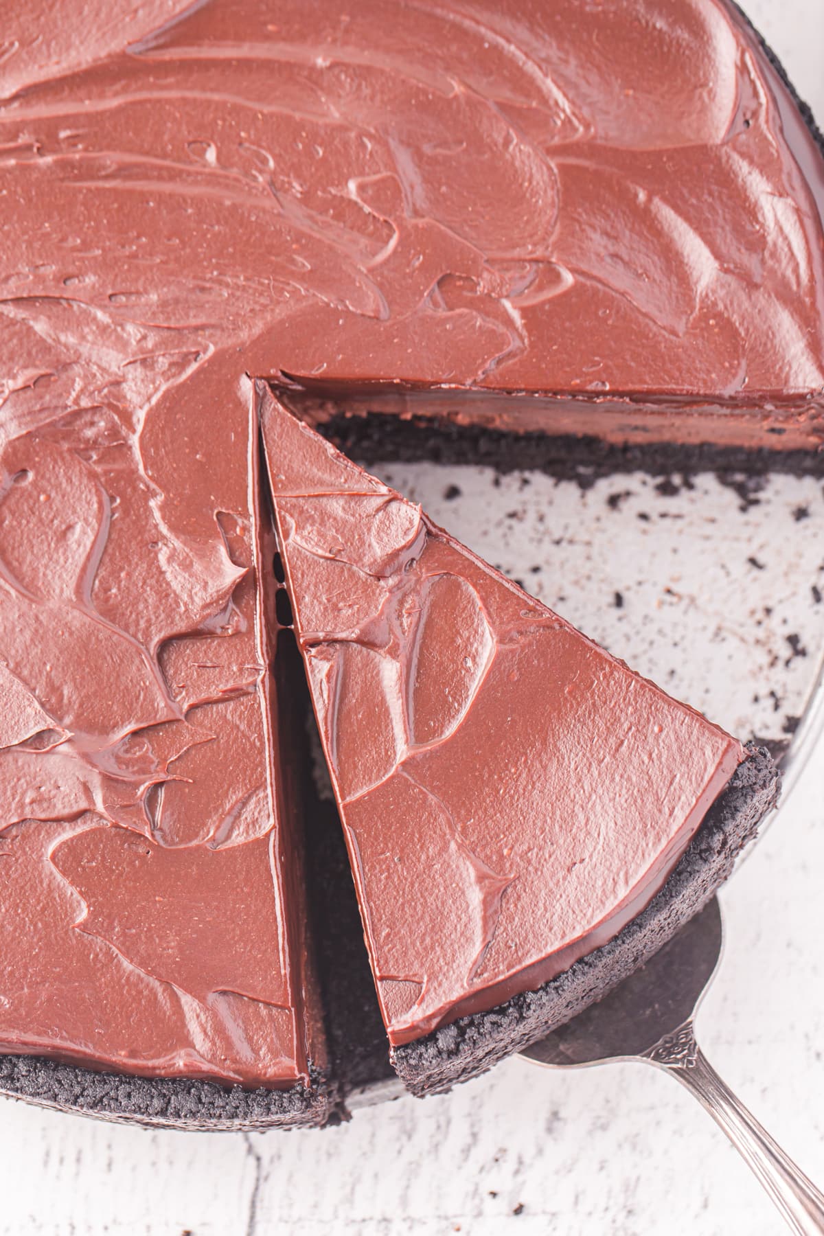Over head shot of a chocolate cheesecake on a white plate.
