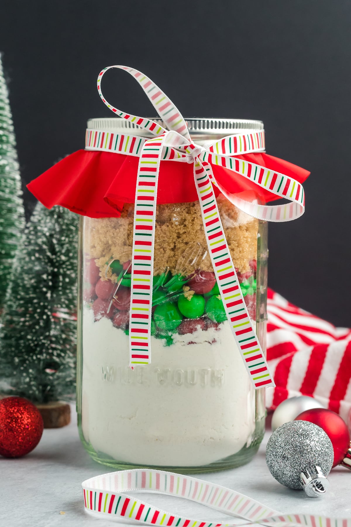 Christmas Cookie mix in a clear mason jar ready to give as a gift.