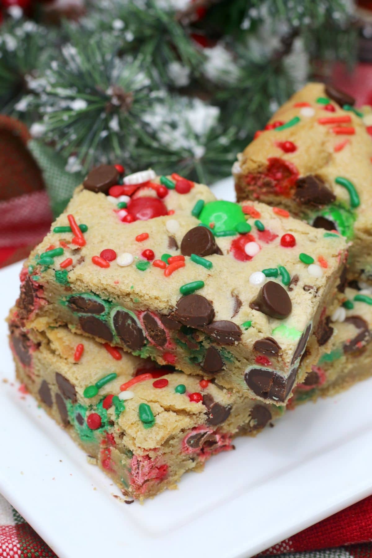 Christmas Cookie Bars on a plate with snow frosted decorations next to it.