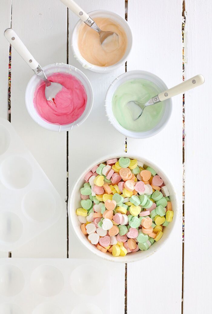 Dishes of colored white chocolate and candy conversation hearts