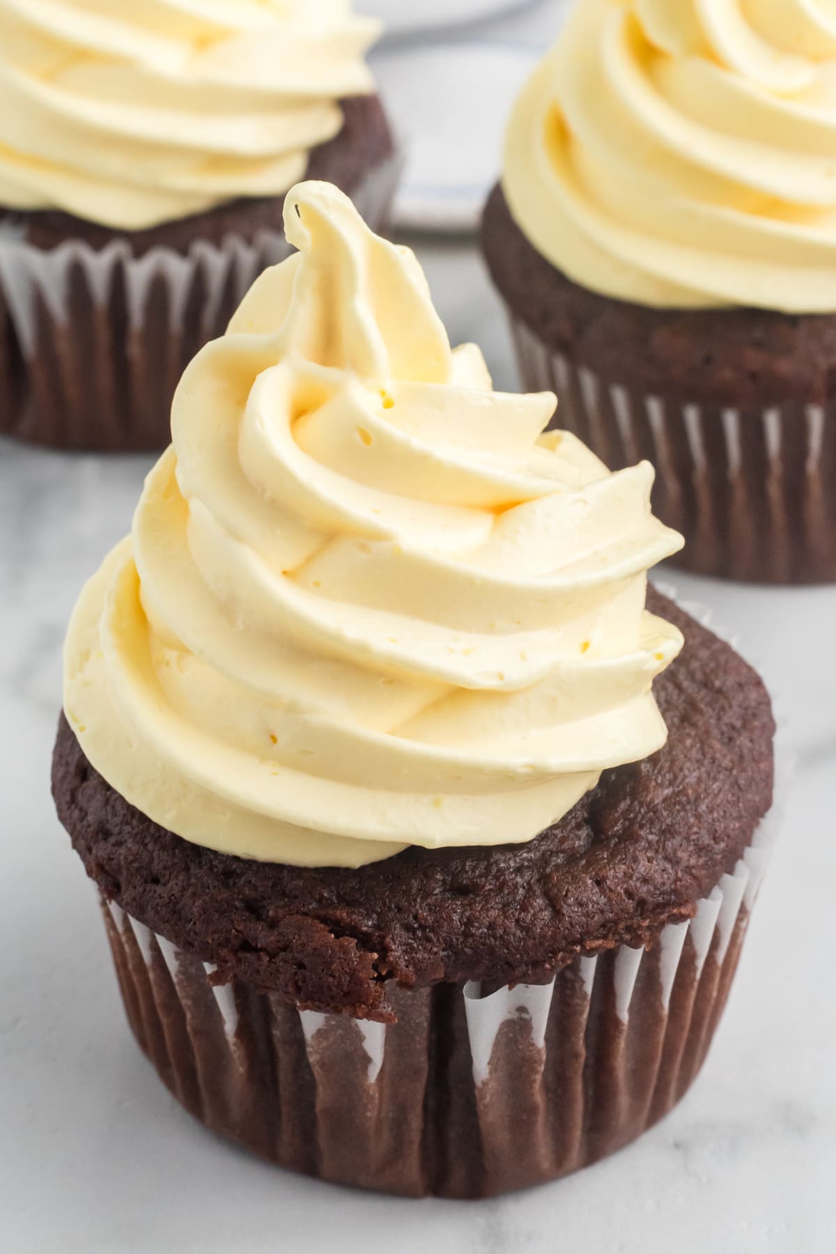 Close up of a chocolate cupcake with cool whip frosting.