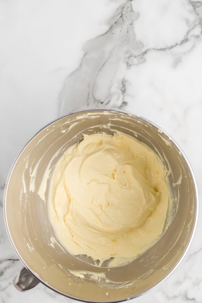 Cool whip frosting in a mixing bowl on a marble background.