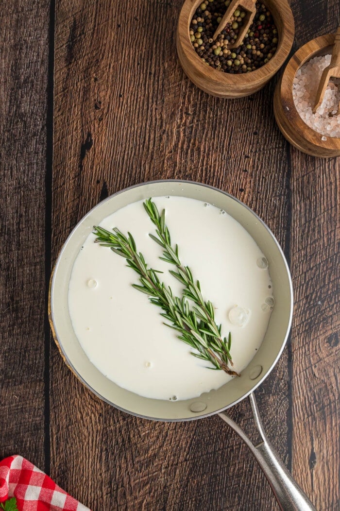 A sprig of rosemary in a small saucepan with half and half
