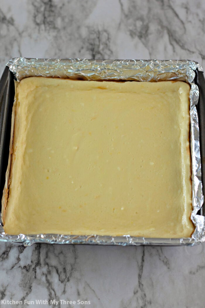 The cheesecake bars in a foil lined baking pan