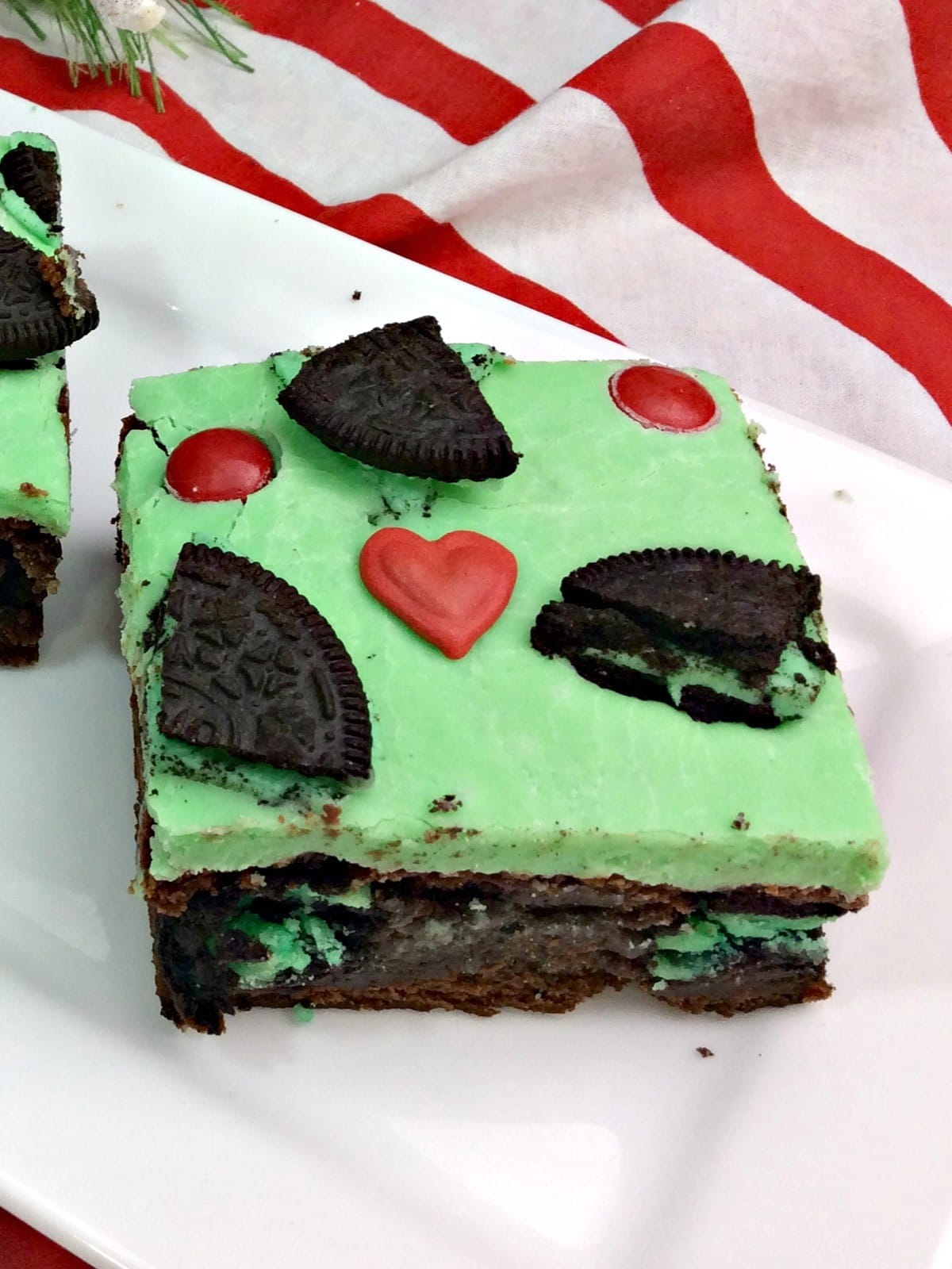 close up of a grinch brownie with green frosting on a plate