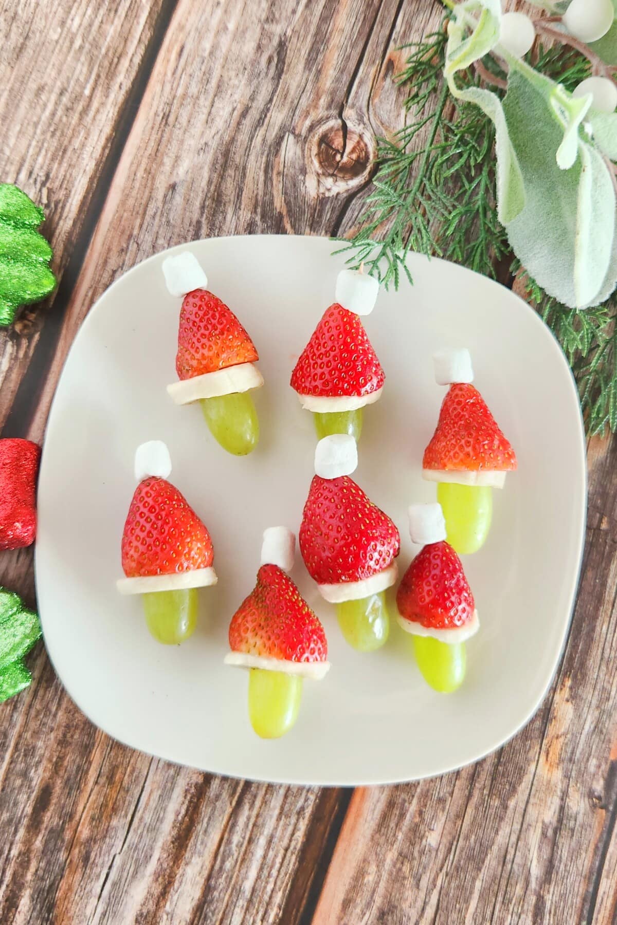 grinch fruit kabobs on a white plate