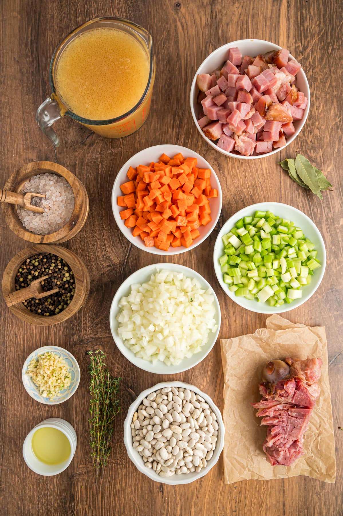 Ingredients on a wood background to make Ham and Bean Soup.