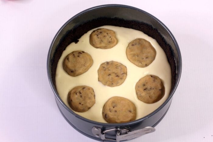 Cheesecake filling and cookie dough in a springform pan.
