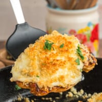 A black spatula serving a piece of parmesan crusted chicken