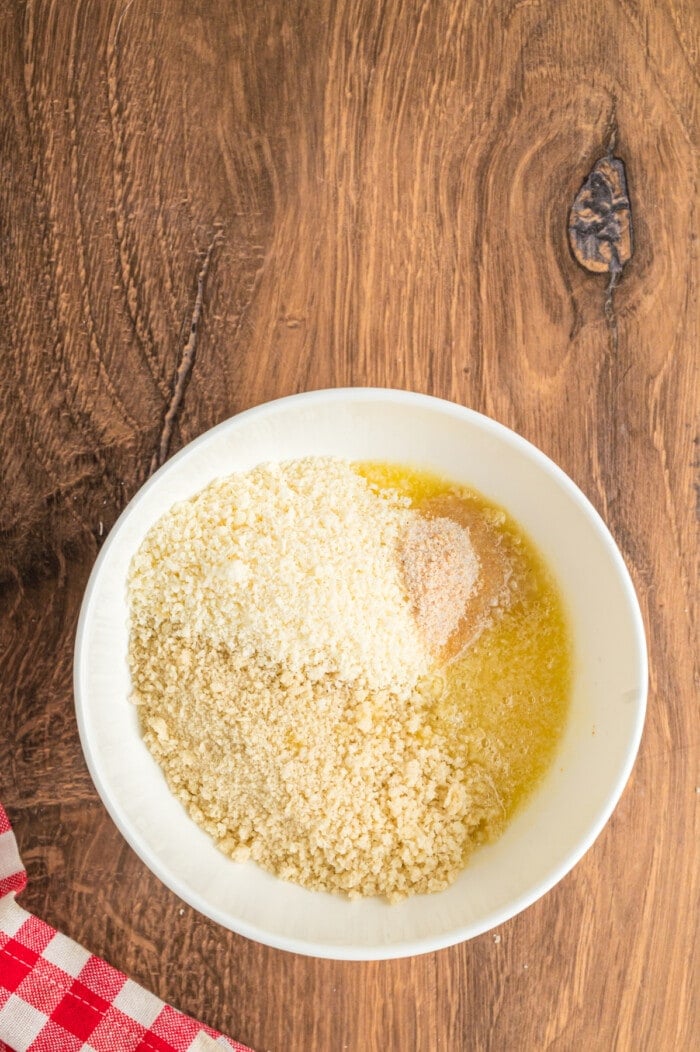 Breadcrumbs, parmesan, and melted butter in a white bowl