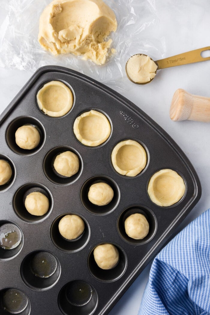 Adding the dough to a mini muffin pan 
