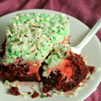 Red velvet poke cake on a plate with a fork
