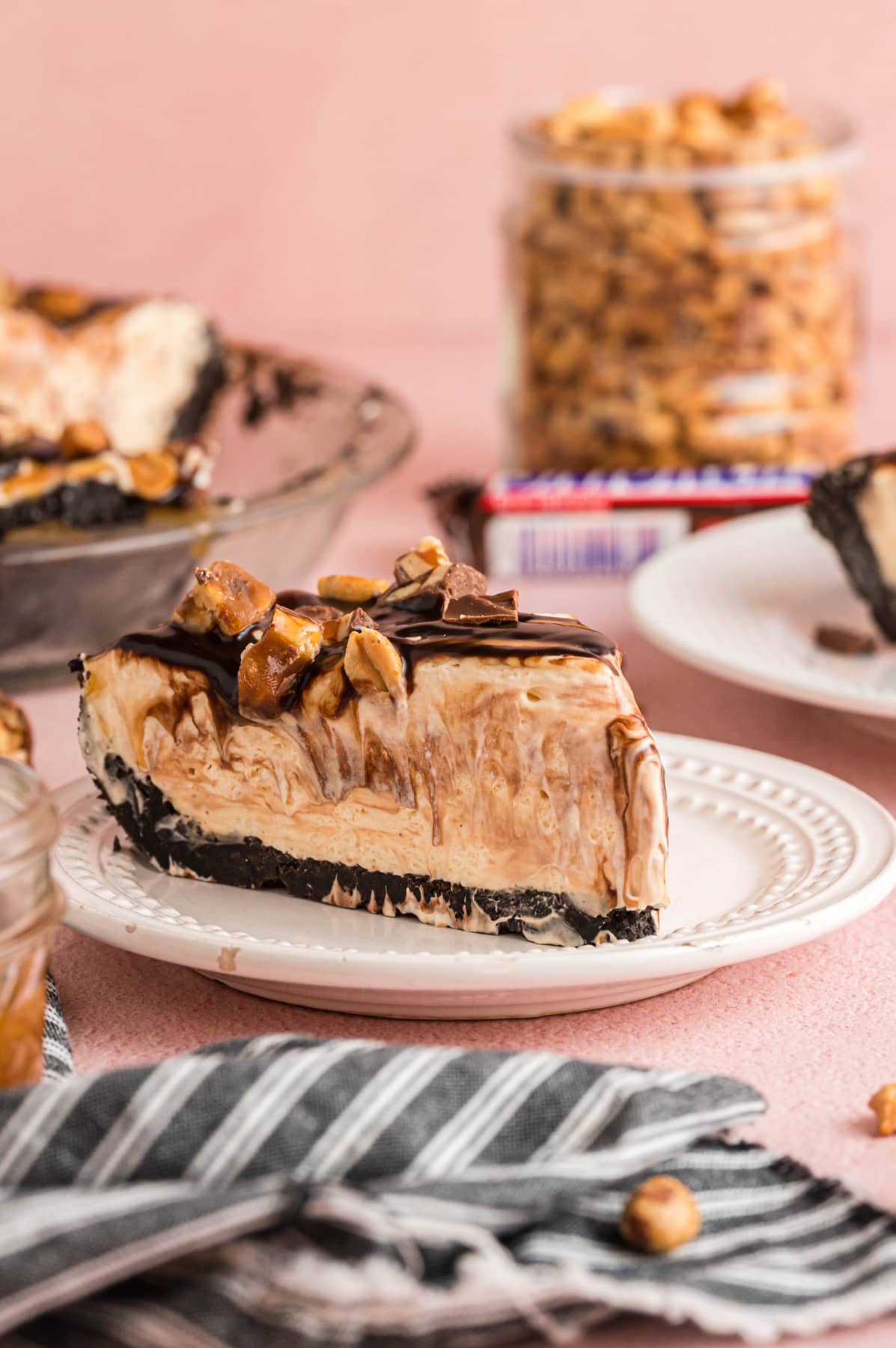 A slice of Snickers Pie on a white plate.