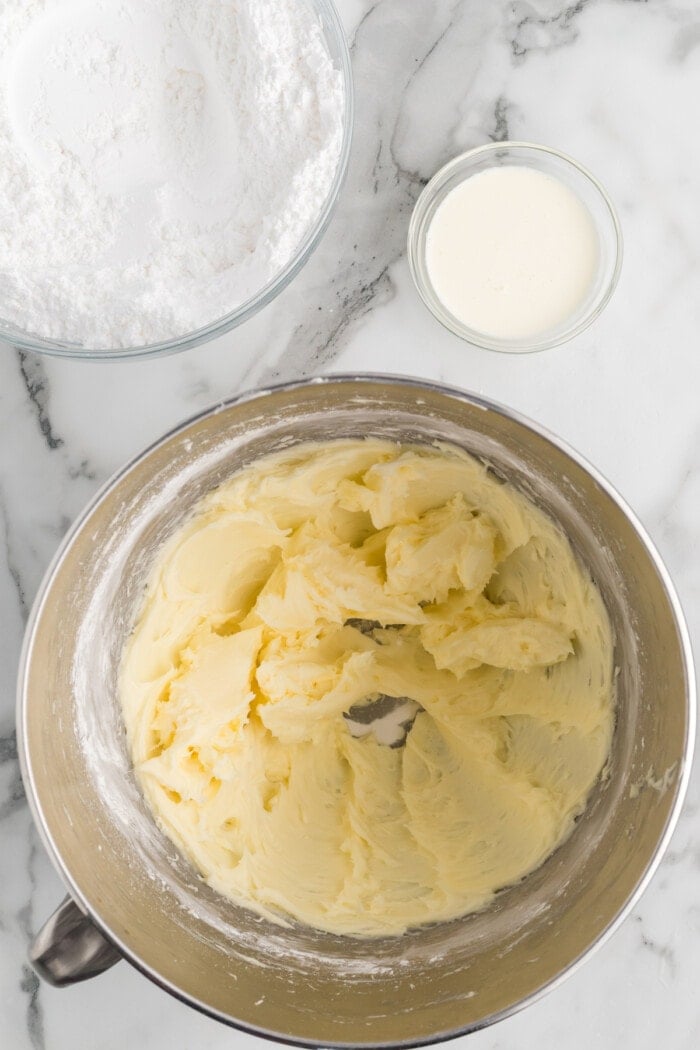 Whipped butter with some powdered sugar in a silver mixing bowl