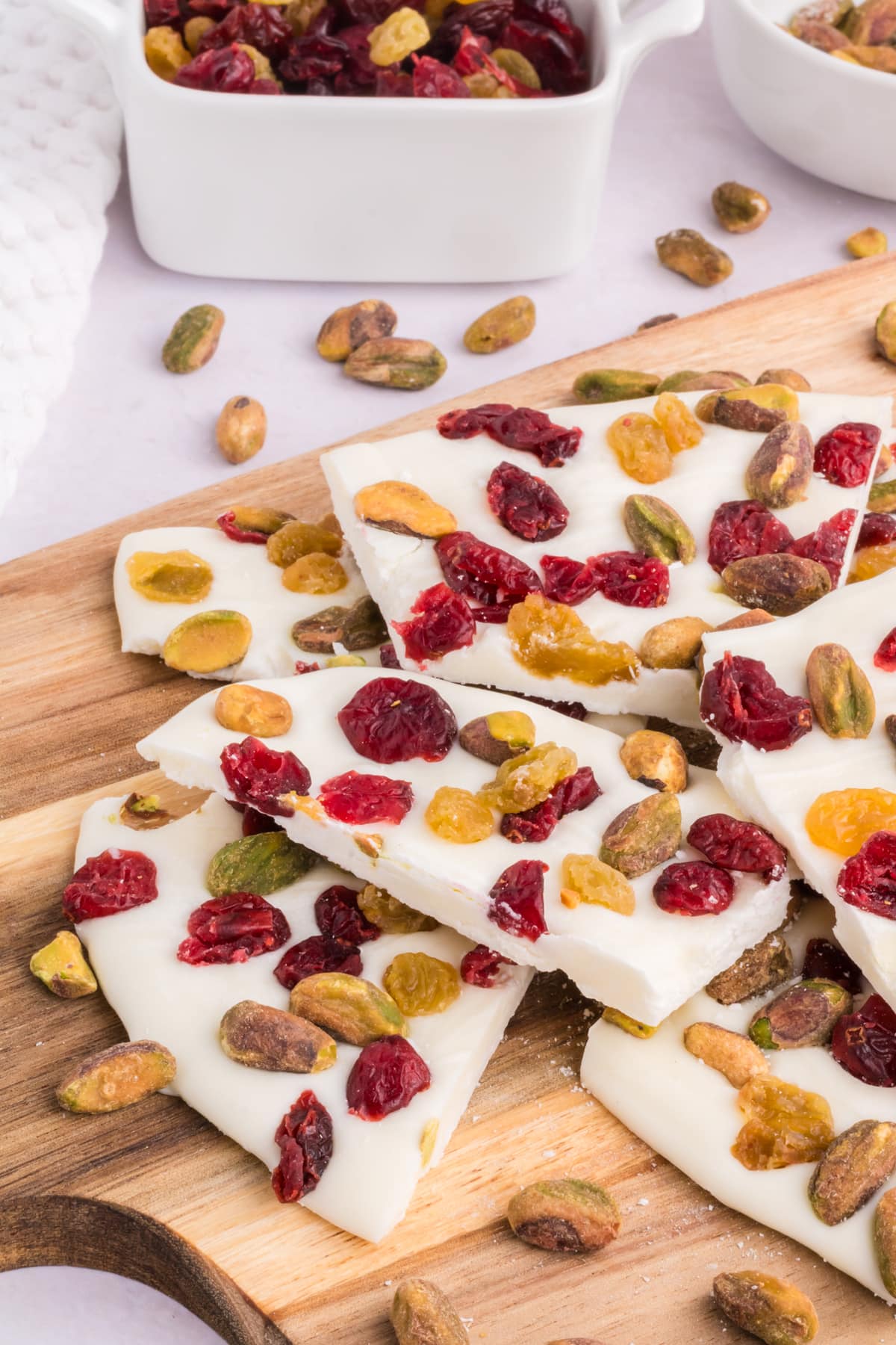 Pieces of white chocolate bark on a wood cutting board.