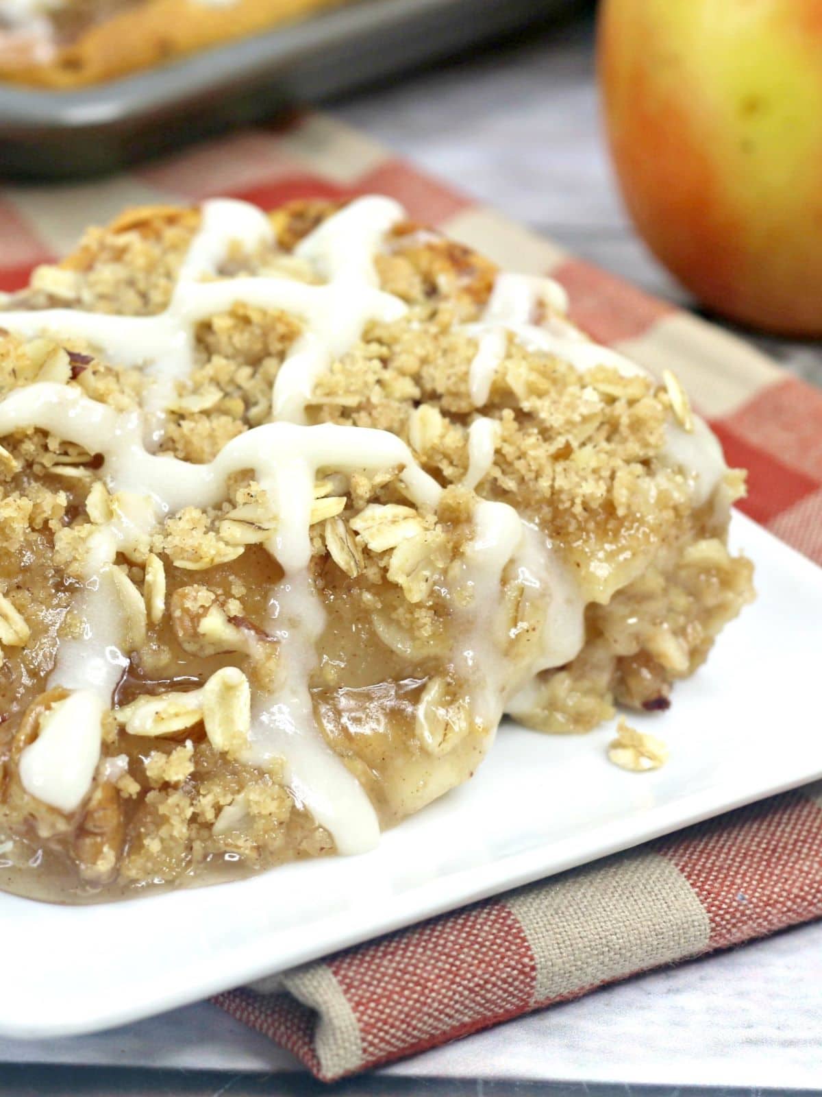 Close up of a slice of apple streusel slab pie on a square plate.