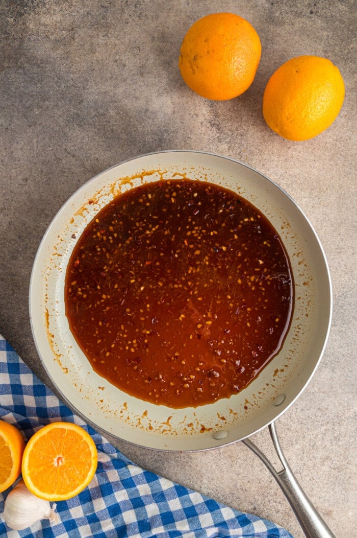 Orange sauce in a white saucepan.