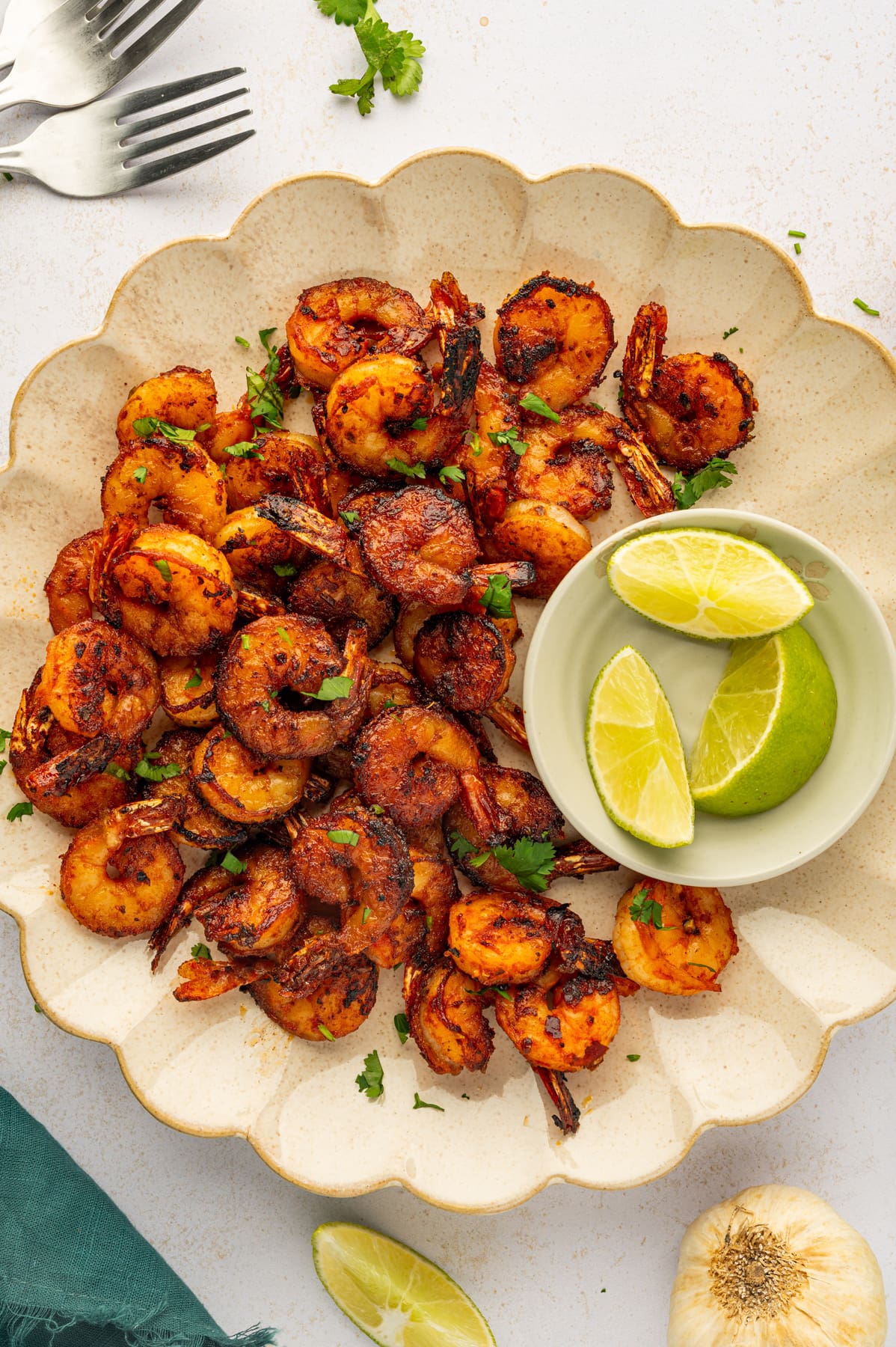 Overhead view of blackened shrimp on a bowl with lime wedges