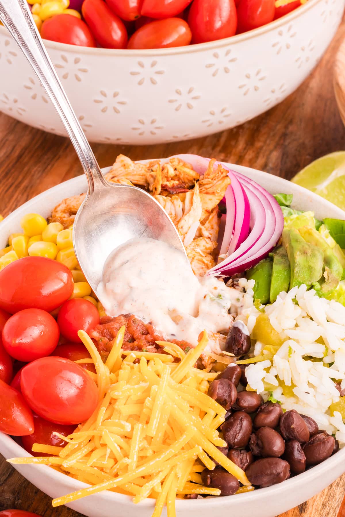 Chicken Burrito Bowl on a wood countertop with a silver spoon.
