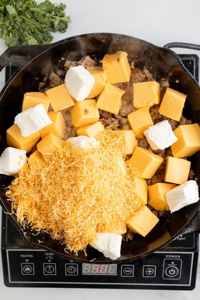 Cheese melting in a cast iron skillet.