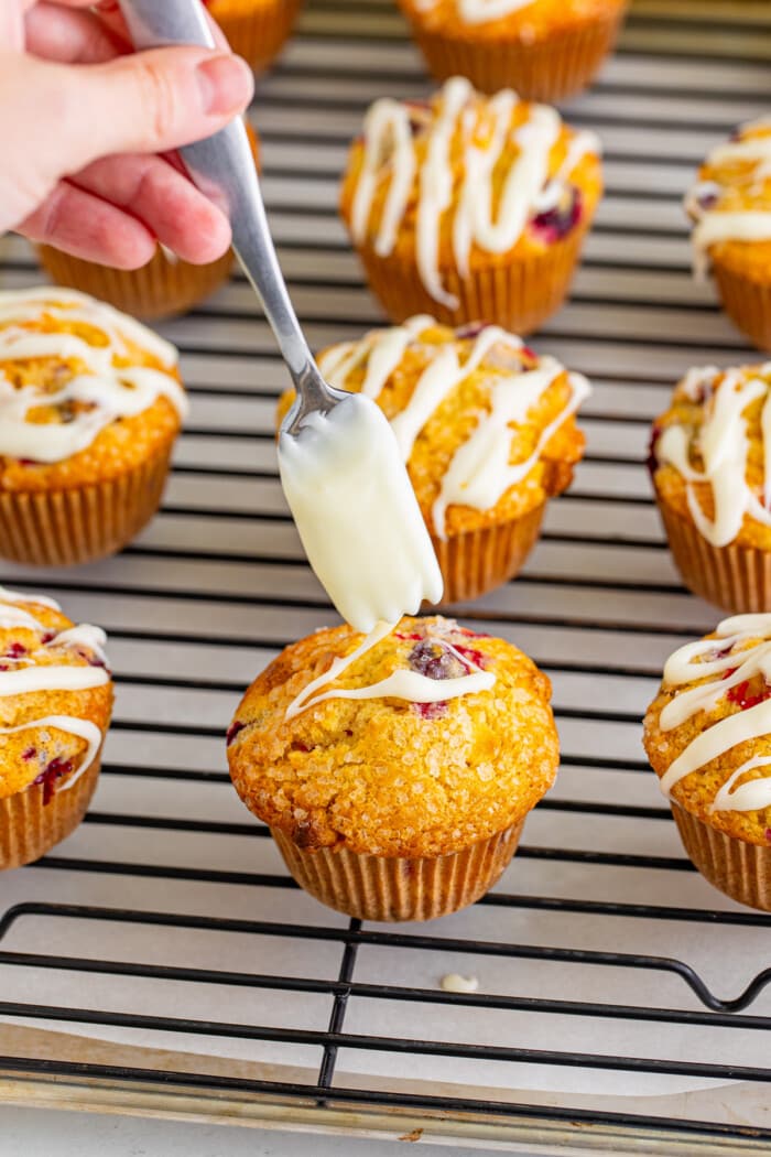 Drizzling frosting onto muffins.