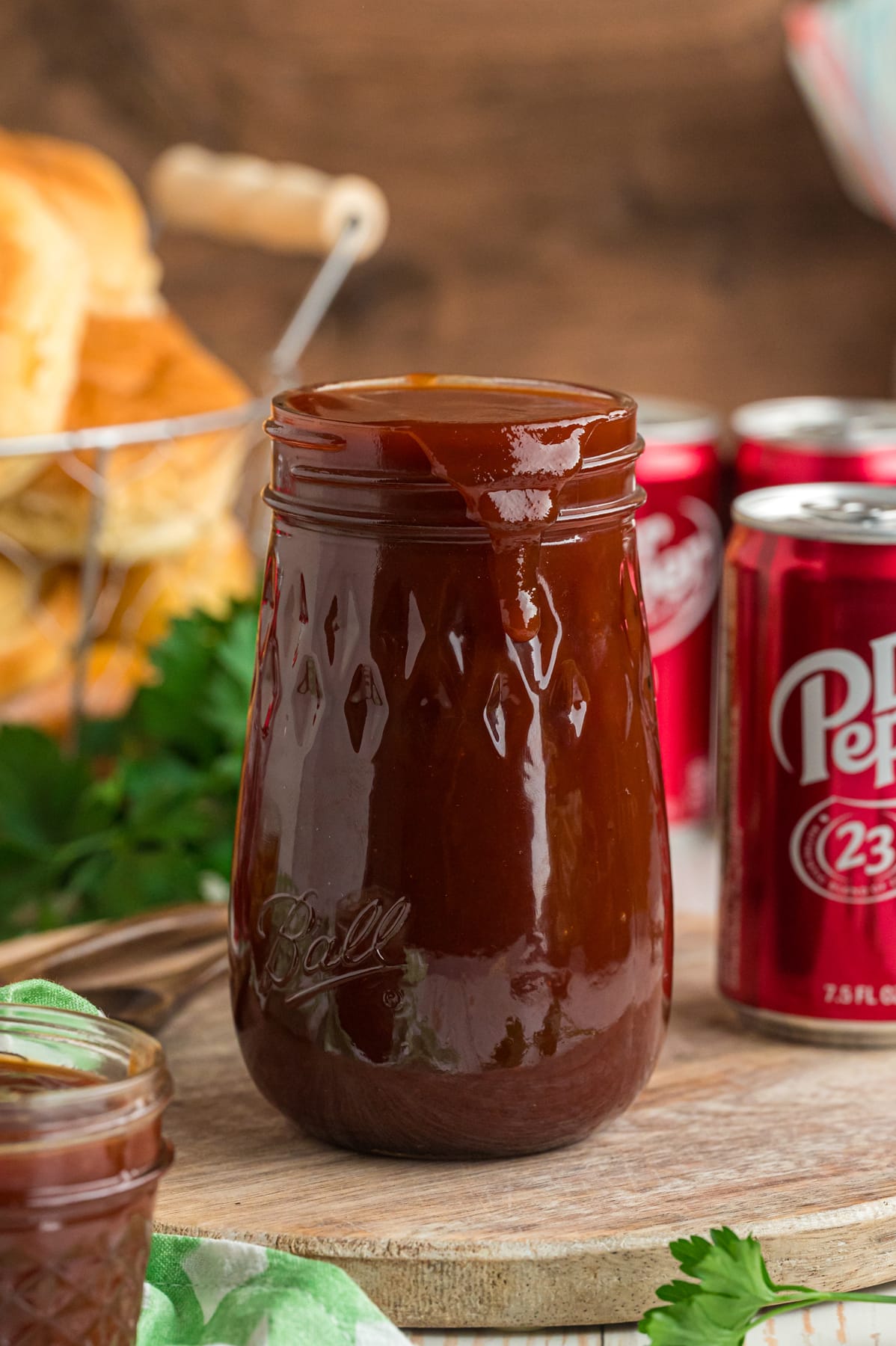 A jar of Dr Pepper BBQ sauce in front of soda cans