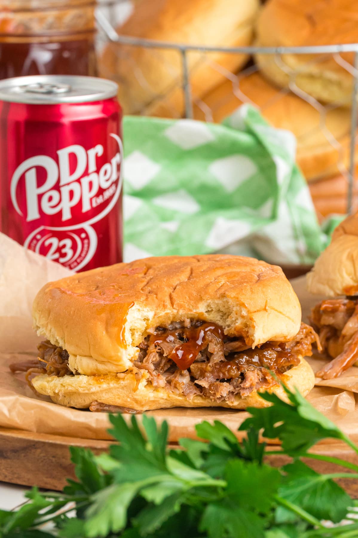 A pulled pork Sandwich in front of a can of Dr Pepper