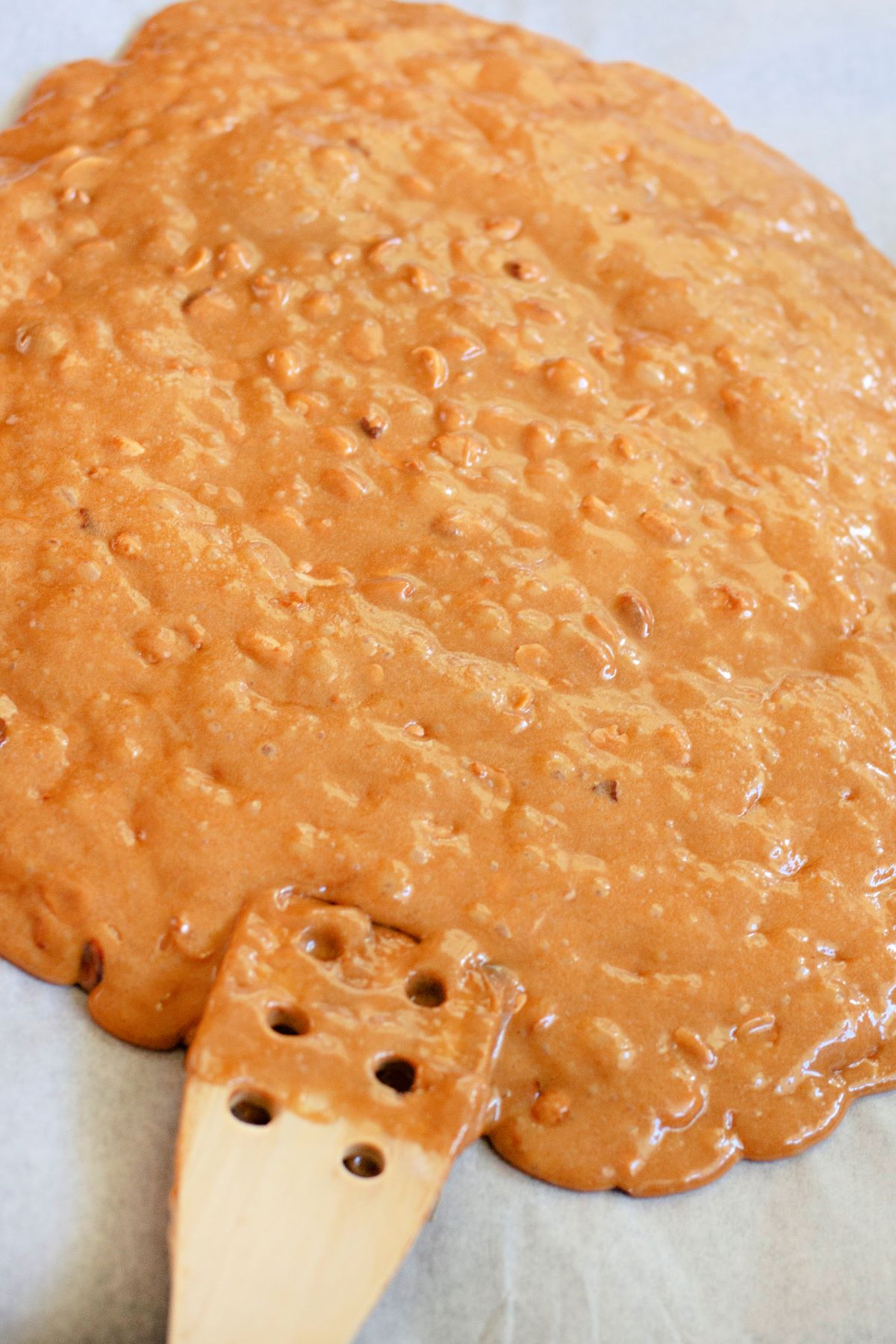 spreading the hot peanut brittle out onto a cookie sheet.
