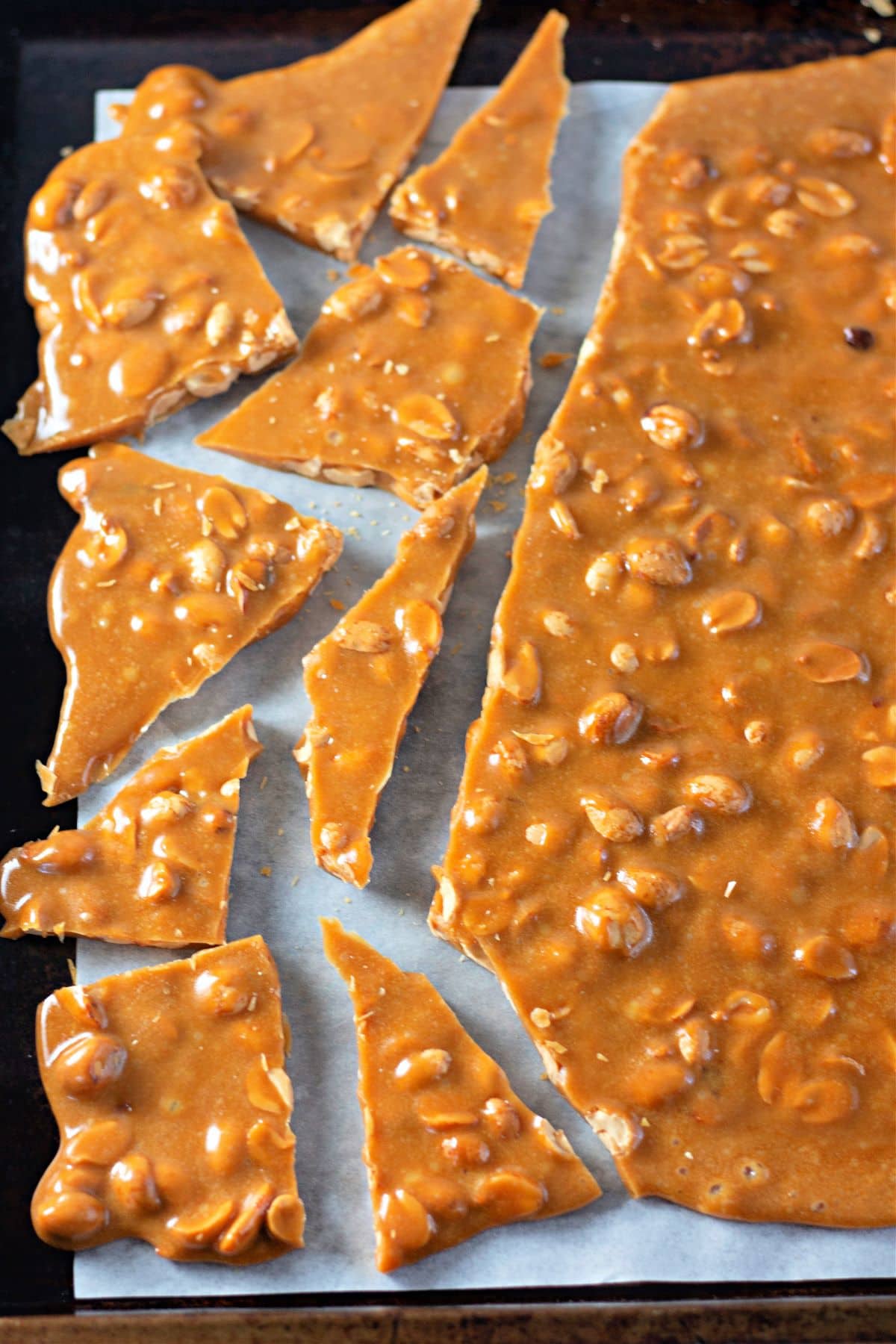 breaking up the freshly made Homemade Peanut Brittle Recipe.