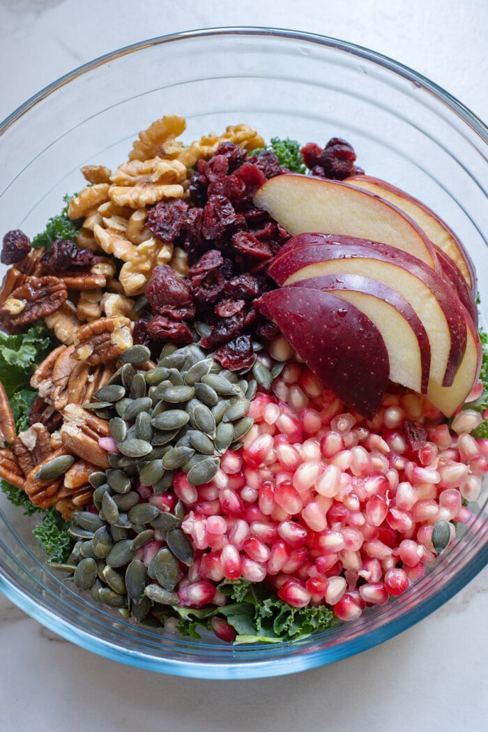 Ingredients for a Pomegranate Salad in a mixing bowl.