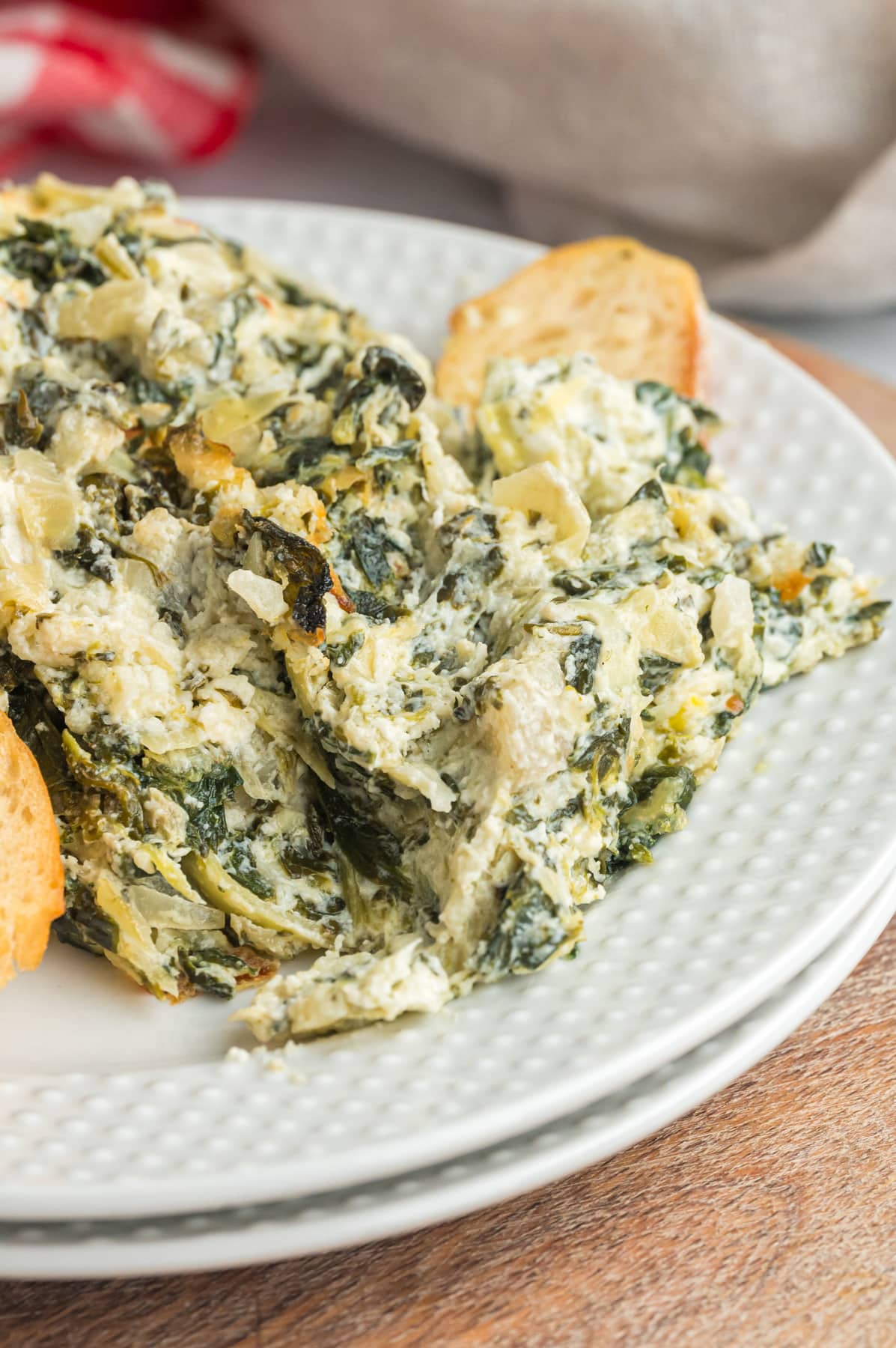 Spinach artichoke dip served on a white plate.