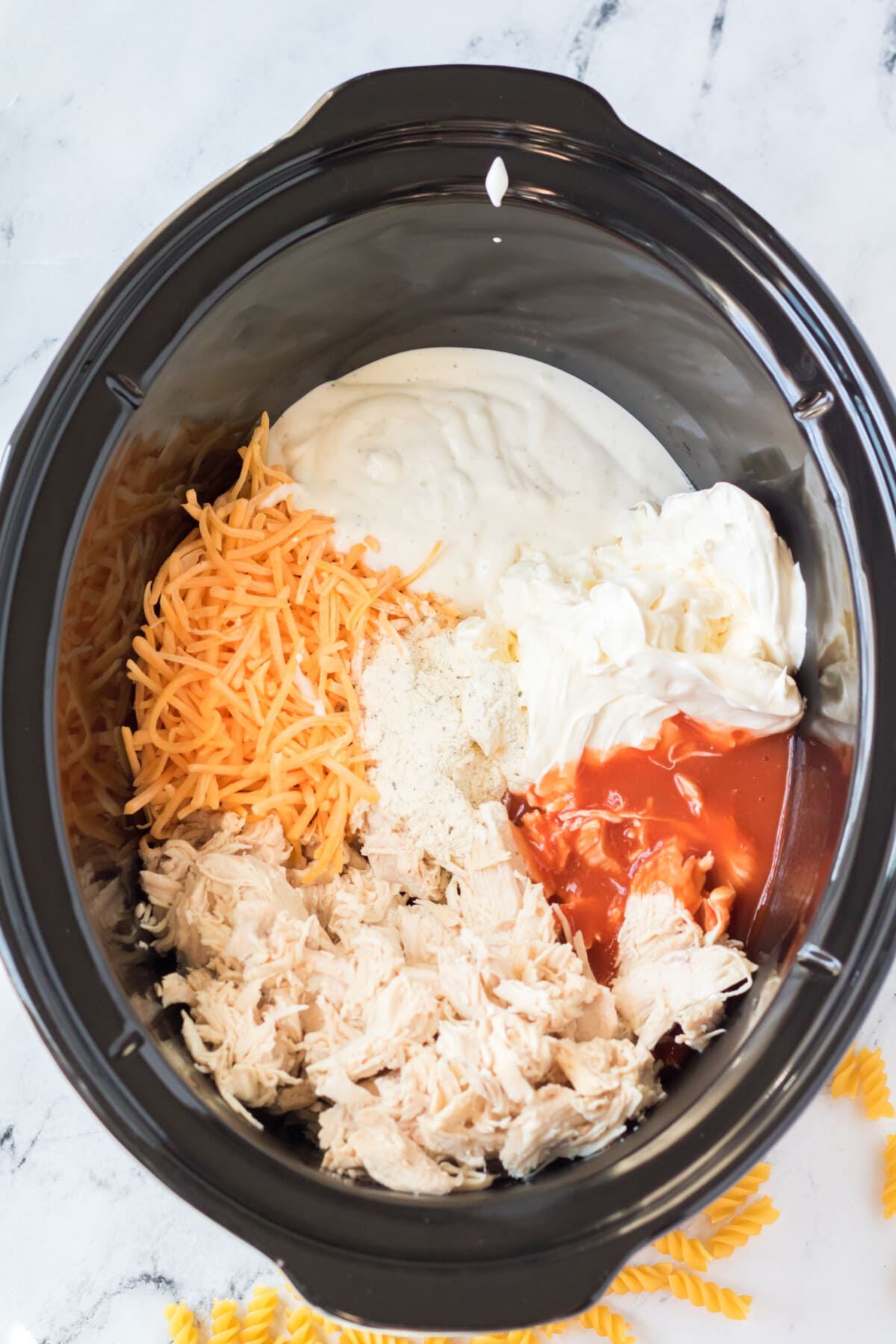 ingredients for Buffalo Chicken Mac and Cheese in a crockpot