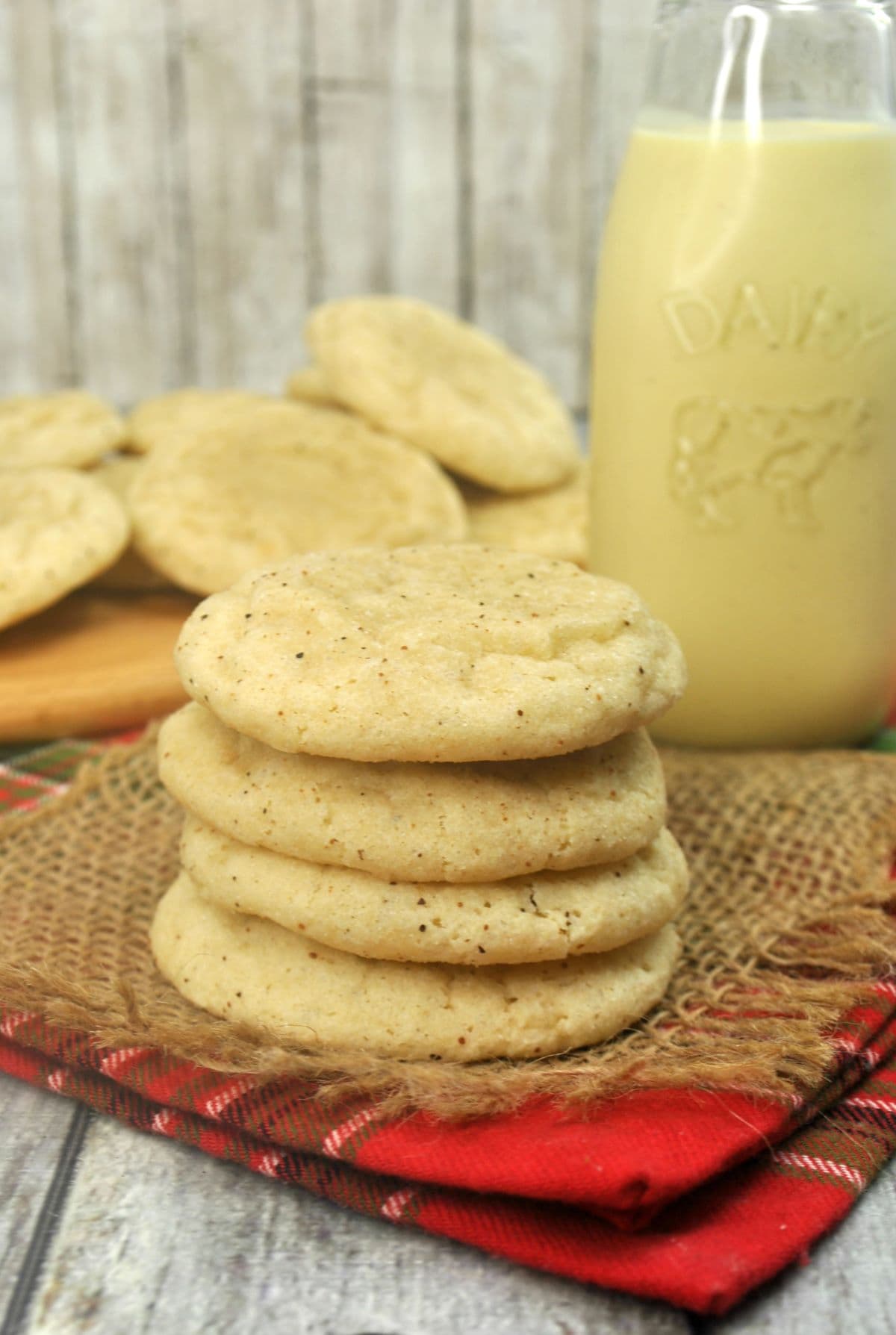 a stack of four eggnog cookies and a bottle of eggnog