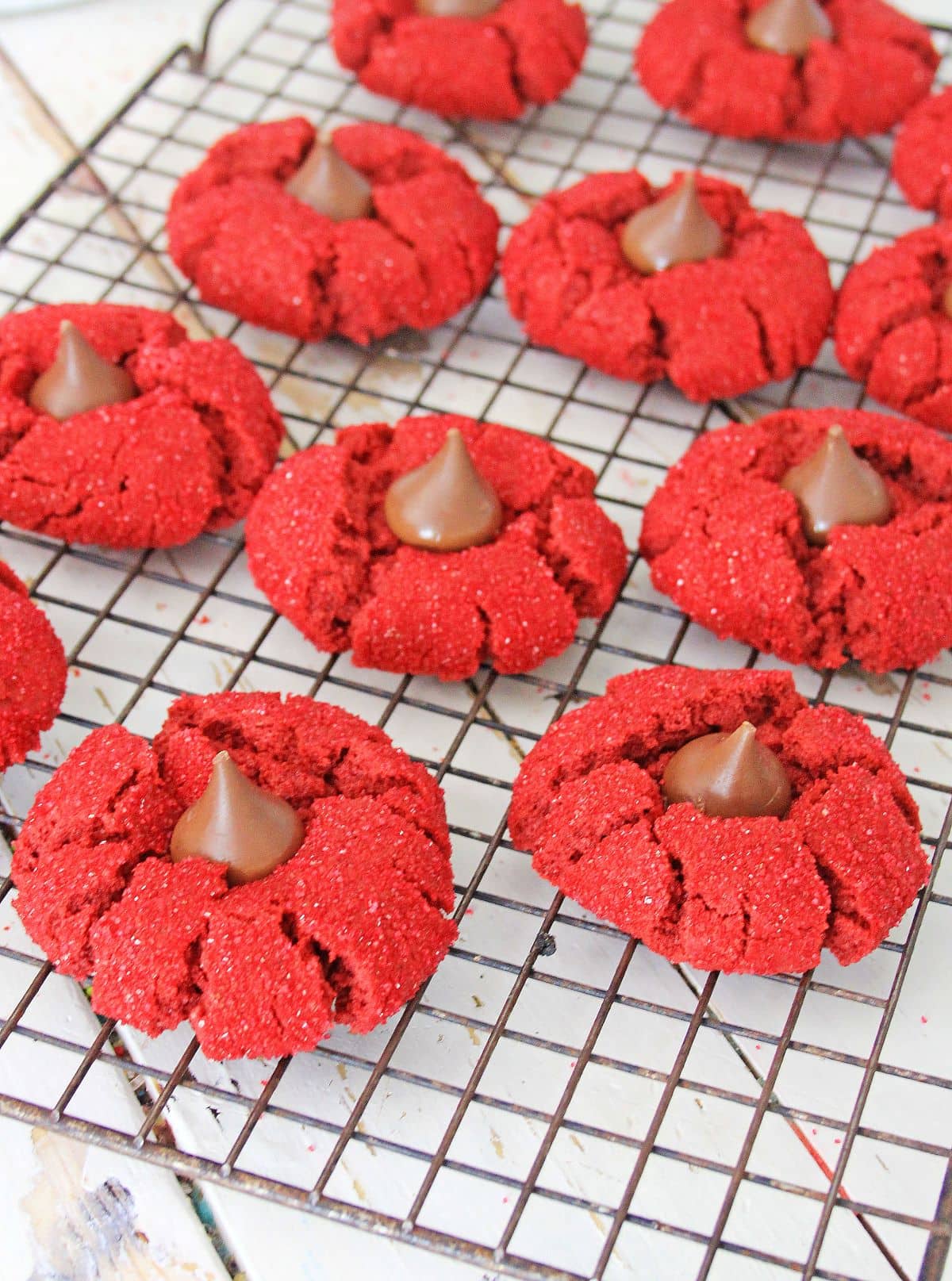 red velvet peanut butter blossom cookies cooling on a wire rack