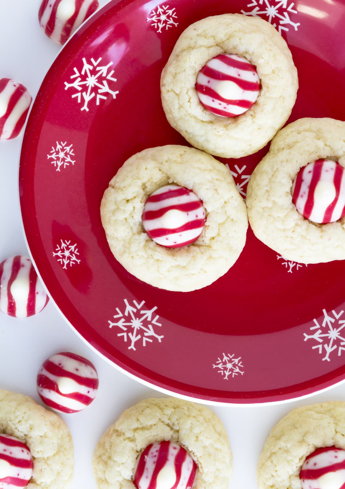peppermint kiss cookies on a red plate with snowflakes