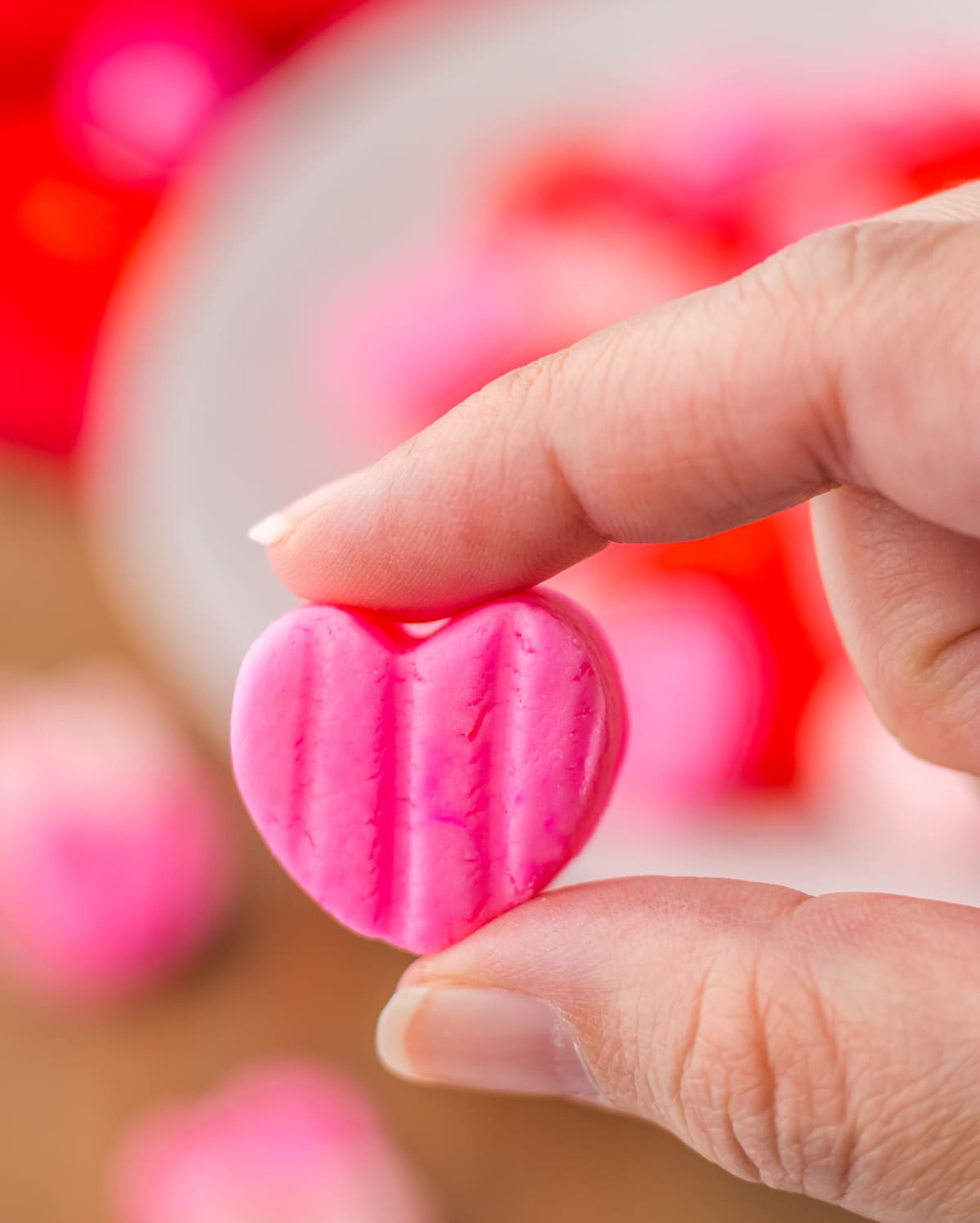 hand holding pink heart cream cheese candy