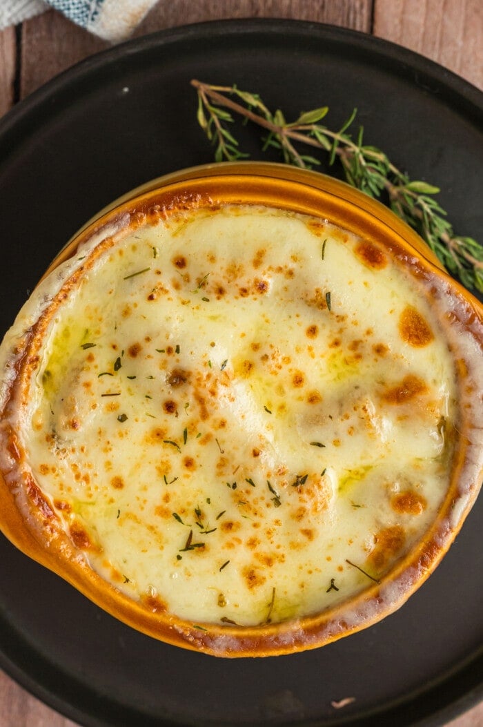 Overhead view of a bowl of French onion soup with provolone melted on top