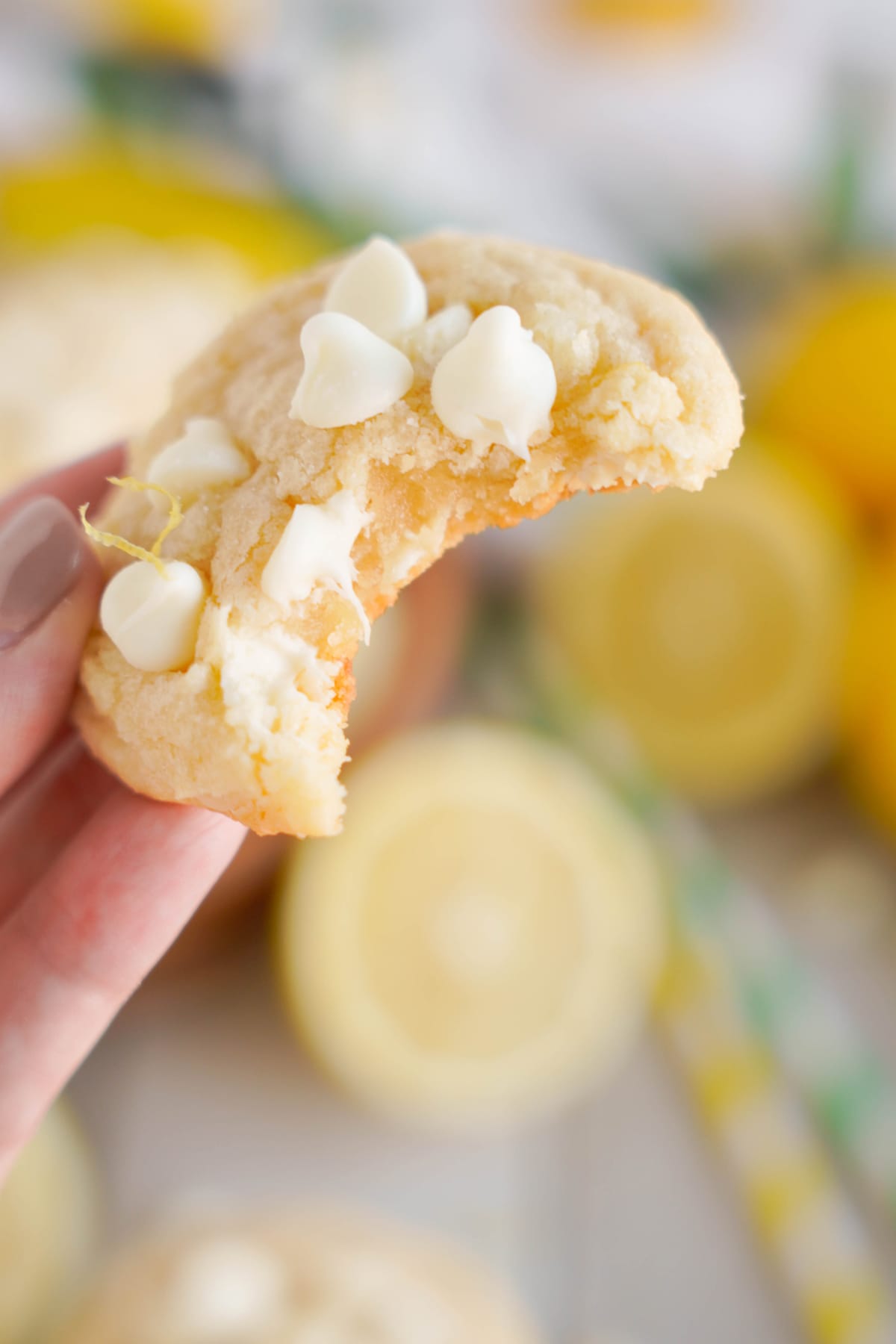 hand holding Lemon White Chocolate Cookies with bite out