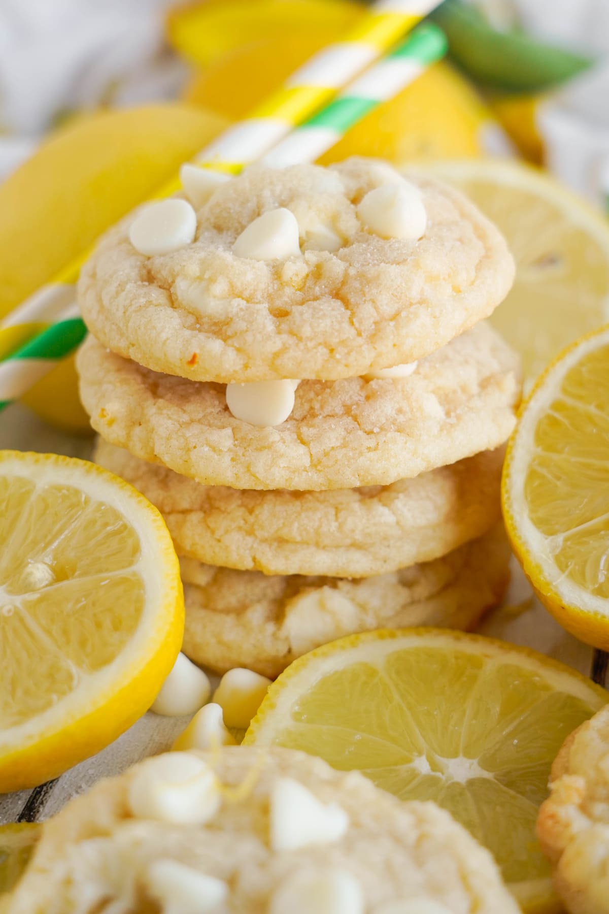 lemon white chocolate cookies stacked with fresh lemons