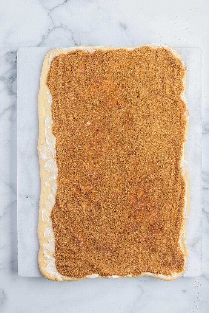 Cinnamon sugar spread on a rectangle of dough