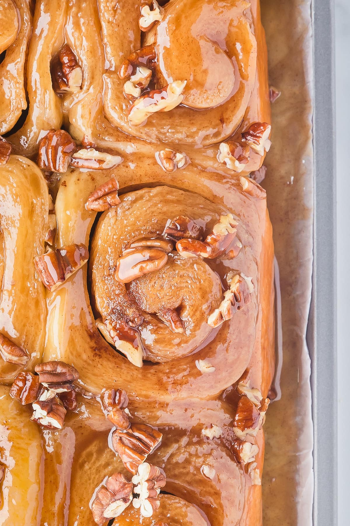 Close up of pecan sticky buns on a baking sheet