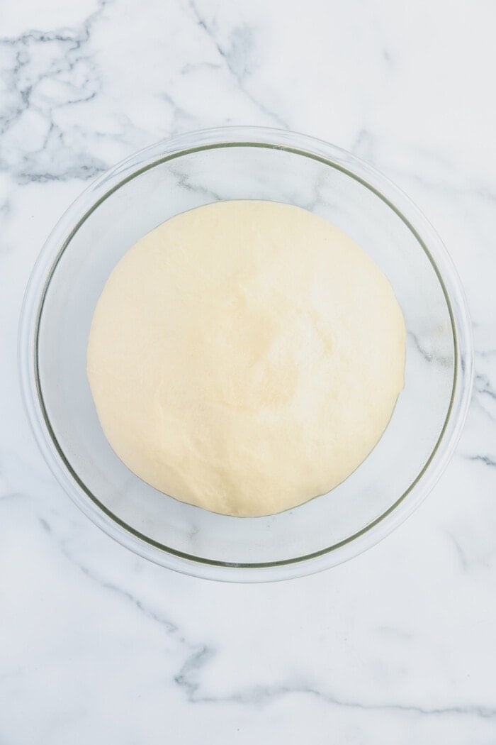 A bowl of risen dough in a bowl