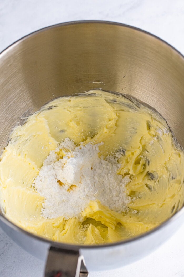 Powdered sugar added to butter in a mixing bowl to make Buttercream frosting for Wedding Cupcakes.
