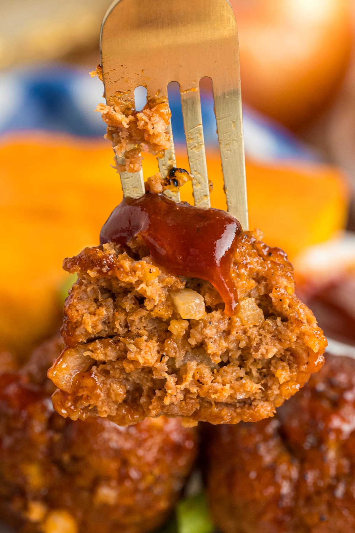 A BBQ meatball cut in half on a fork