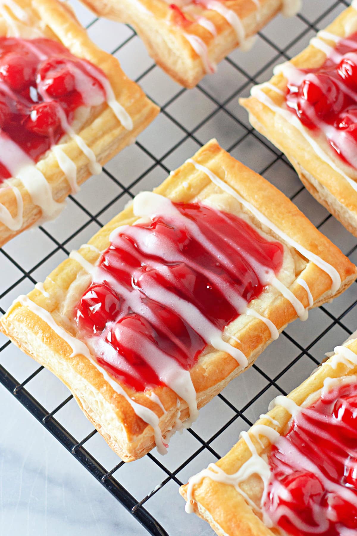 cherry danish with cream cheese filling on cooling wire rack