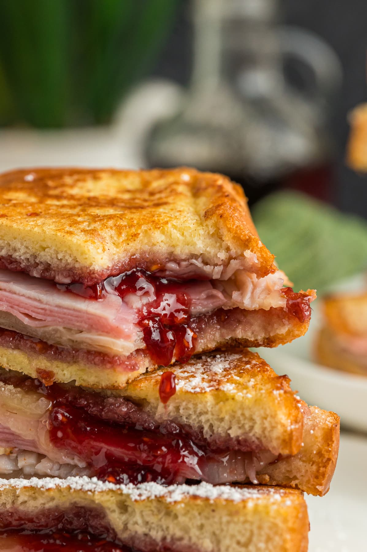 A Monte Cristo sandwich stacked on each other, with a bite missing to show the jam