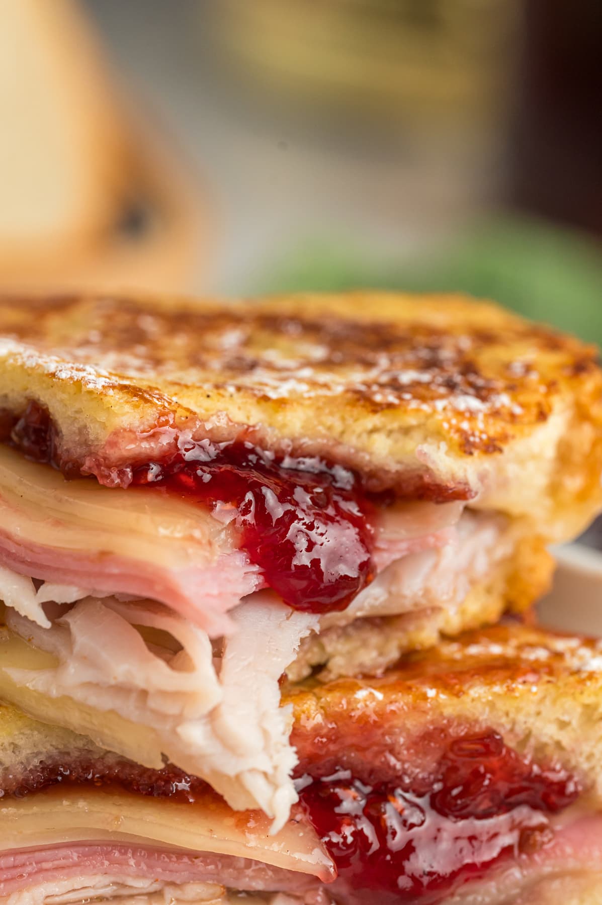 Close up of two halves of a Monte Cristo sandwich with jam spilled out the side