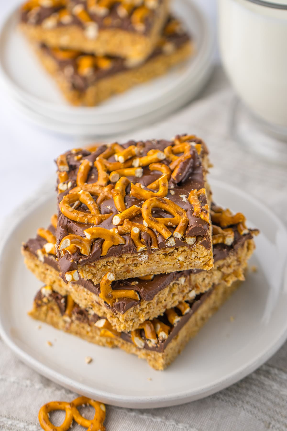 These Chocolate Peanut Butter Pretzel Bars are the ultimate sweet and salty no-bake treat with only 6-ingredients and just 10-minutes of prep! Peanut Butter Pretzel Bars stacked on plate