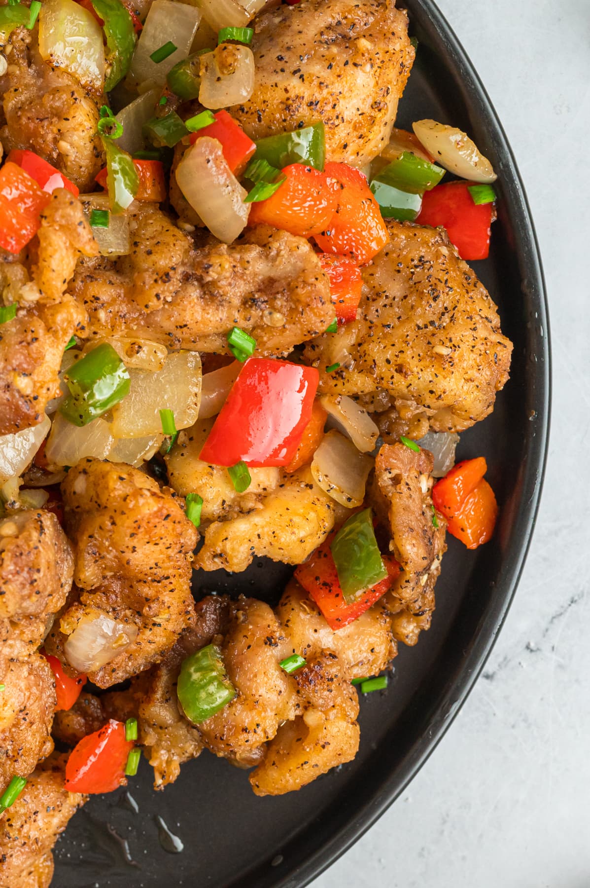 Close up of salt and pepper chicken in a skillet
